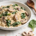 Creamy mushroom and spinach orzo in a black skillet