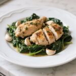 Garlic chicken with spinach served on a plate