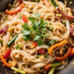 Gluten free rice noodles and vegetables stir fry in wok