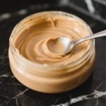 Homemade Peanut Butter in a Glass Jar on Black Marble