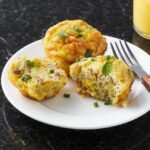 Scrambled egg muffins on a white plate over black marble countertop