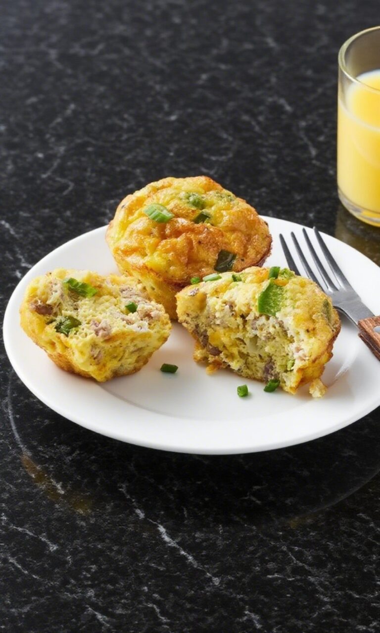 Scrambled egg muffins on a white plate over black marble countertop