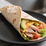 Turkey wrap served on black plate