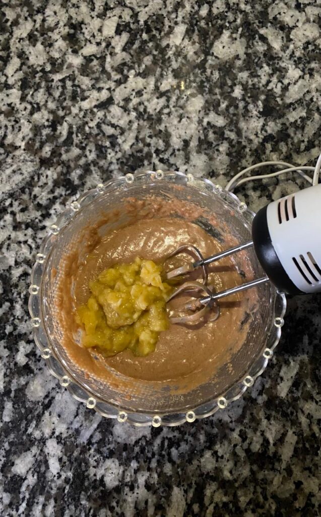Mashed ripe bananas being added to the batter