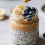 Almond butter chia pudding topped with blueberries in a glass jar