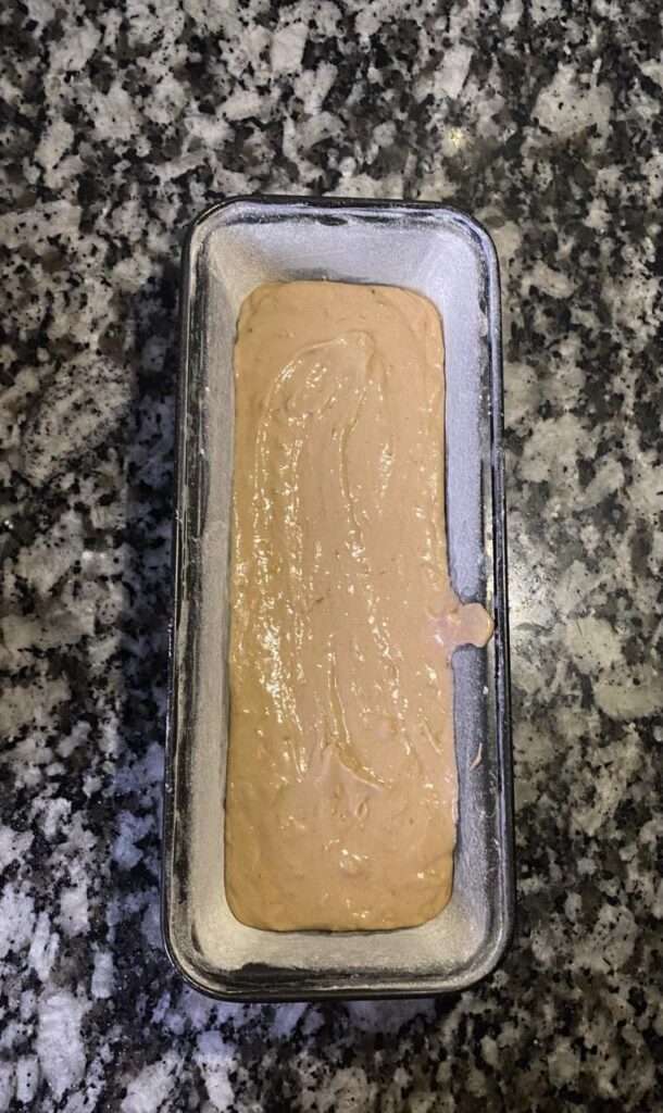 Banana bread batter poured into a loaf pan