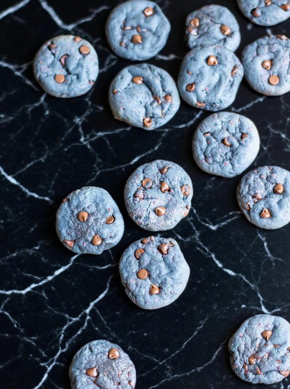 Freshly baked blackberry cookies with melted chocolate chips on tray