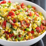 Fresh corn salad with tomatoes, peppers, and Cotija cheese close-up